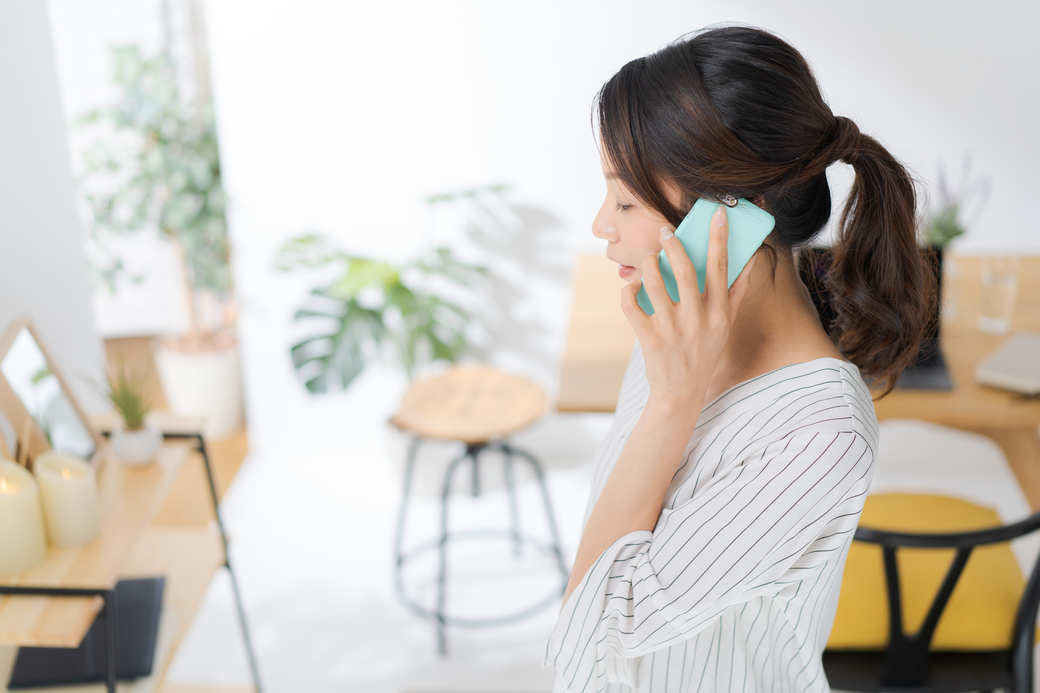 住まいの気になることを電話で相談する女性