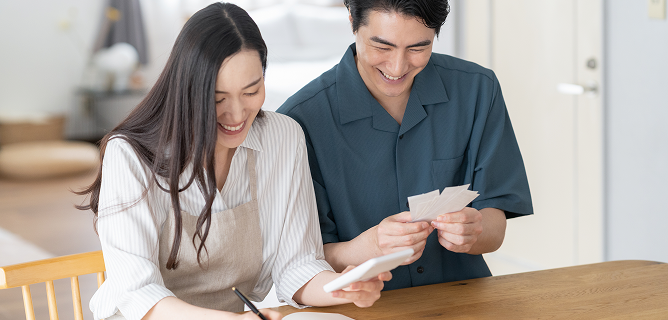 家計簿を見ながら光熱費を確認する夫婦
